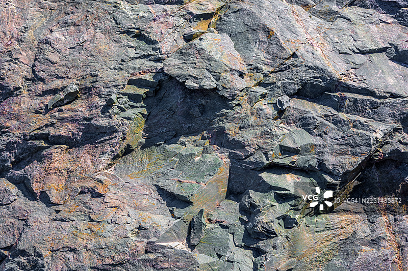 岩石纹理的完整画面，具有崎岖的表面和自然的色彩变化图片素材