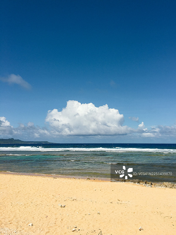 宁静的热带海滩，拥有金色沙滩和绿松石般的海水，碧空如洗，白云朵朵图片素材