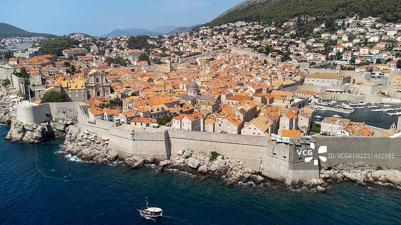 克罗地亚杜布罗夫尼克历史悠久的城墙内城市空中俯瞰图，海滨坐落于亚得里亚海旁，海港内有船只停泊，杜布罗夫尼克，克罗地亚图片素材