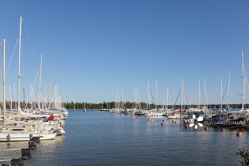 晴朗蓝天下，宁静的码头停泊着许多帆船，位于芬兰图片素材