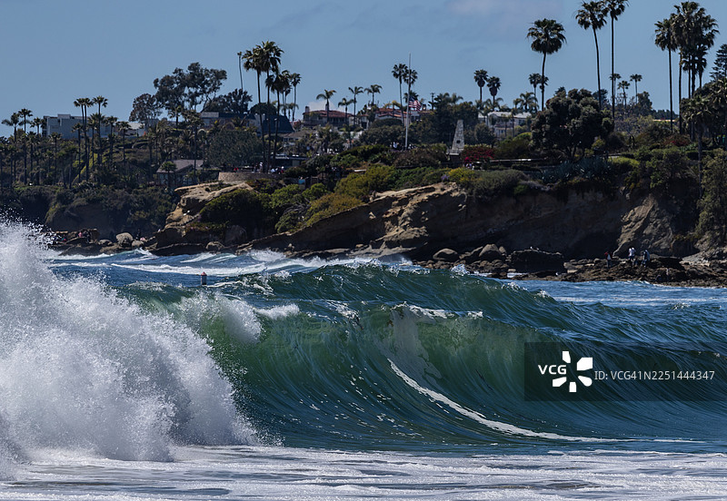蓝天下的海岸城镇背景，强大的海浪拍打着海岸，美国图片素材