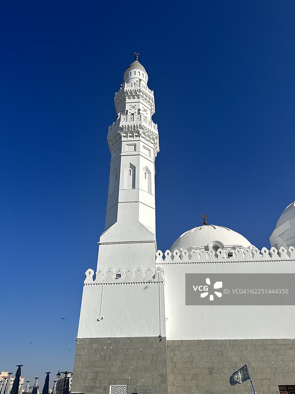 沙特阿拉伯麦地那，雄伟的白色宣礼塔和清真寺圆顶在晴朗的蓝天下，展现建筑之美与精神内涵。图片素材