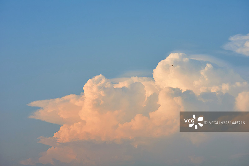 从低角度拍摄的戏剧性积云，衬托着蓝天，沐浴在温暖的阳光下，泰国图片素材
