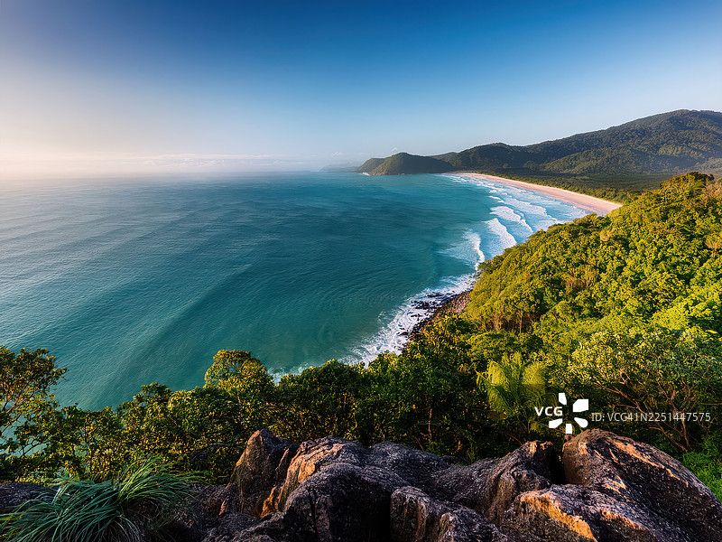 澳大利亚道格拉斯角，纯净的热带海滩与苍翠的山峦在晴空下交汇于碧绿的海洋，令人惊叹的航拍景象图片素材