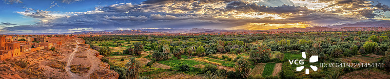 摩洛哥廷希尔，令人印象深刻的绿洲日落景观，天空布满云彩图片素材