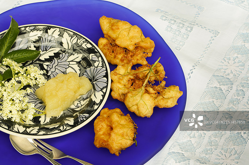 施瓦本美食，接骨木莓蛋糕配苹果酱，Hollerkiacherl（接骨木花油炸饼），接骨木花酥皮点心，甜点，甜点，油炸，盛在盘子里，奶奶的厨房，地方特色，家常菜，典型的施瓦本风味，经典食谱，传统美食，食物摄影图片素材