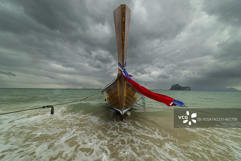泰国南部，沙敦府，安达曼海，格岛，海滩上的长尾船，背景是乌云密布的雨云图片素材