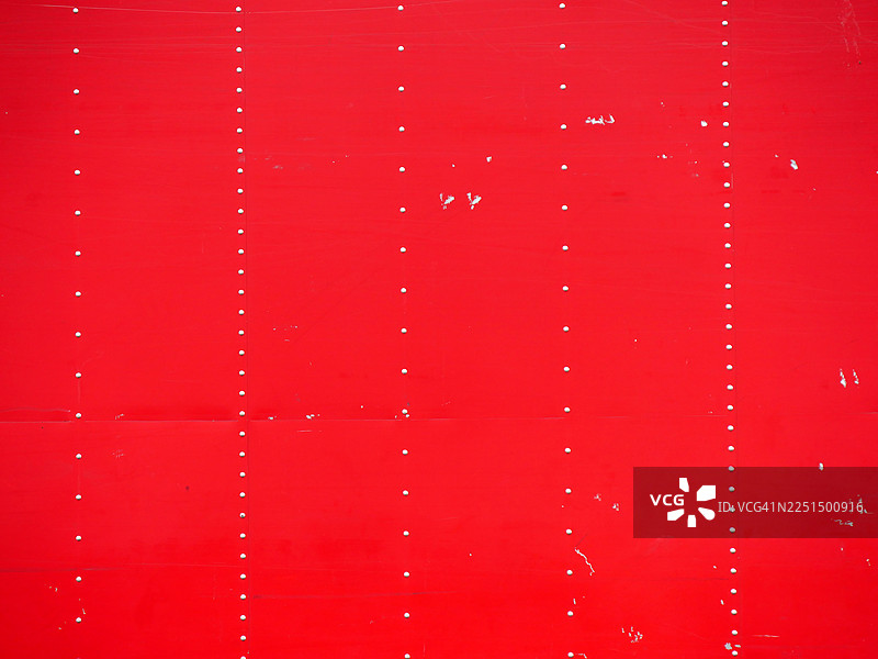 一个红色金属板，铆接且有铜绿。图片素材