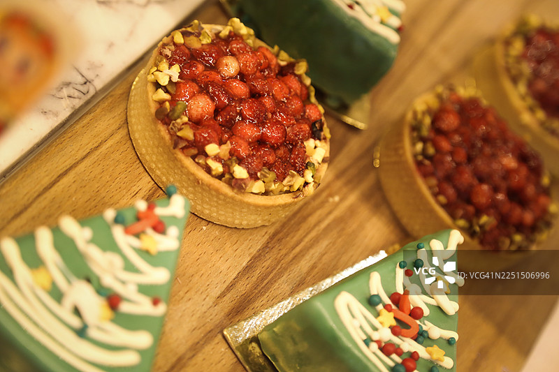 色彩缤纷的圣诞树和野草莓装饰的手工馅饼和蛋糕图片素材