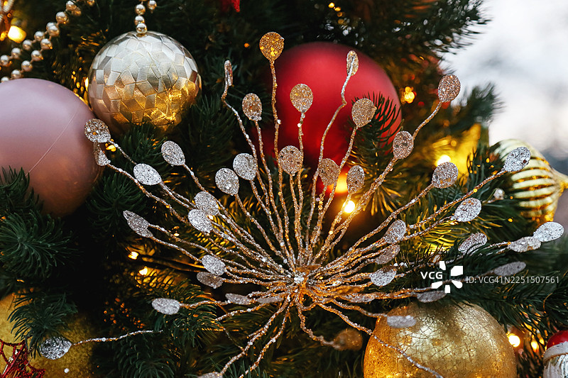 装饰有金色闪亮饰品、小摆设和闪闪发光花环的圣诞树图片素材