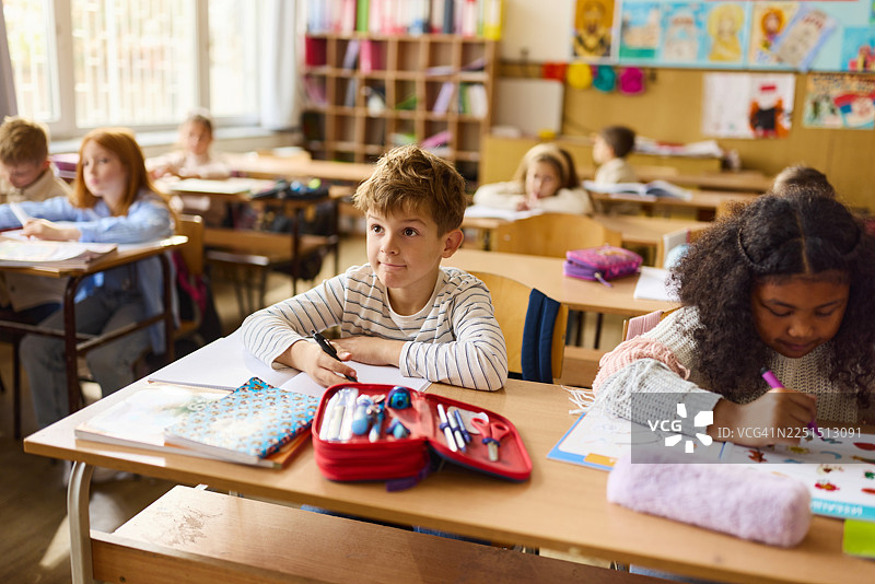 小学生在小学课堂上与朋友们一起认真听讲。图片素材