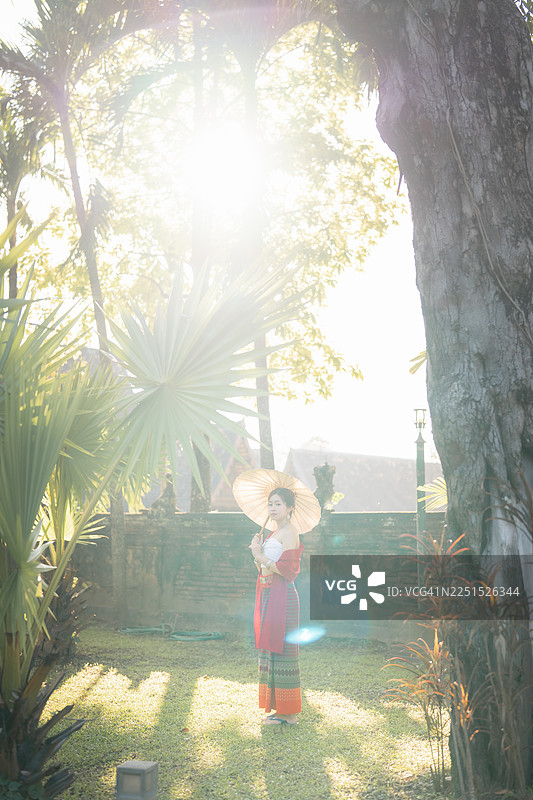 在泰国北部的清迈，年轻女子身着兰纳泰传统服饰在寺庙中旅行。图片素材