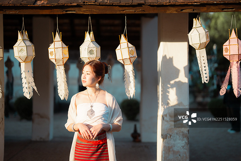 一群年轻貌美的亚洲女士穿着泰国传统服饰，正在探索泰国清迈的Wat Ton Kwen寺庙。图片素材