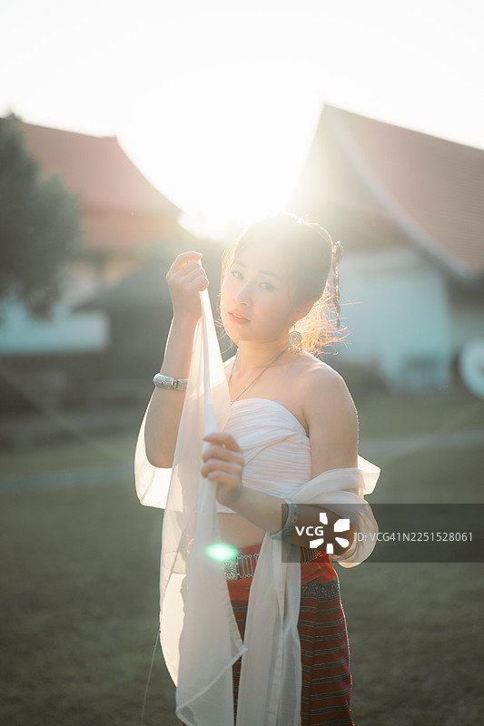 身着泰国传统服饰的年轻貌美亚洲女士正在探索泰国清迈的Wat Ton Kwen寺庙。图片素材