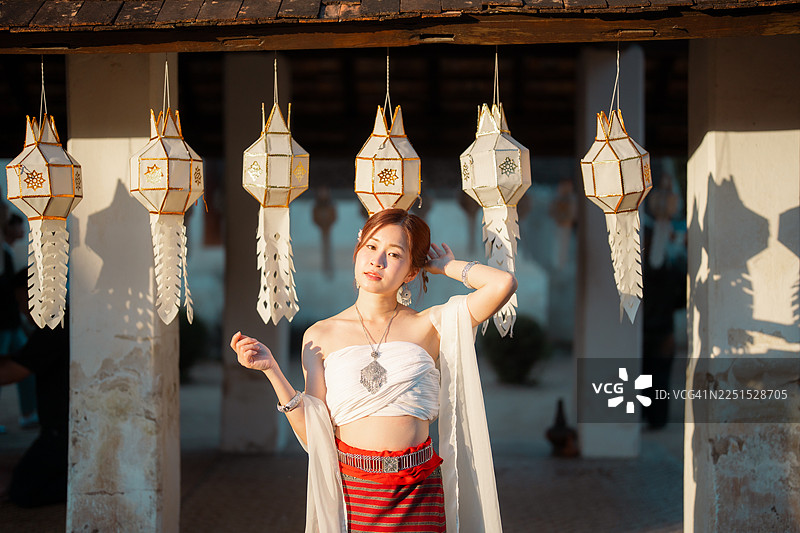 身着兰纳泰国传统服饰的亚洲女性，正在清迈因他瓦兰寺（Wat Intharawat）悠闲地游览。图片素材