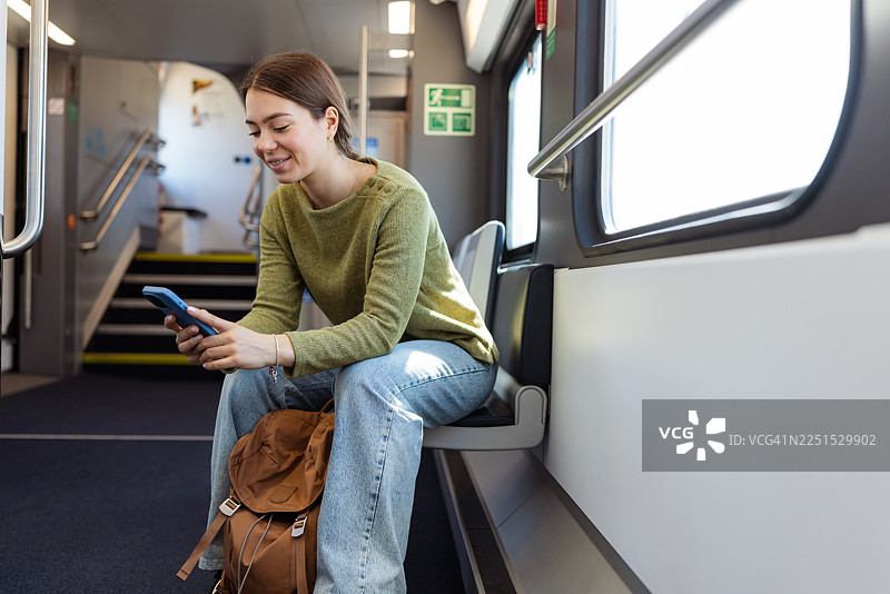 年轻女子在火车上使用手机图片素材