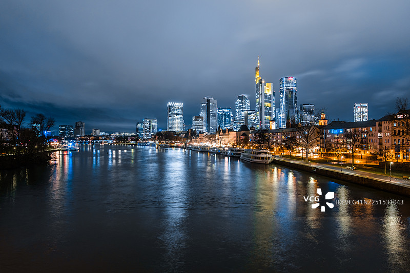 夜幕下的法兰克福天际线，摩天大楼和房屋的倒影映照在美因河上图片素材