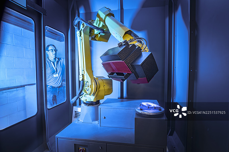 在航空零部件工厂，操作员正在观看机器人扫描已完成的零件以进行质量控制。图片素材