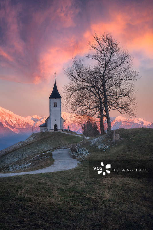 贾姆尼克教堂，夕阳下山顶小路上的宁静山间教堂，周围有光秃秃的树木图片素材