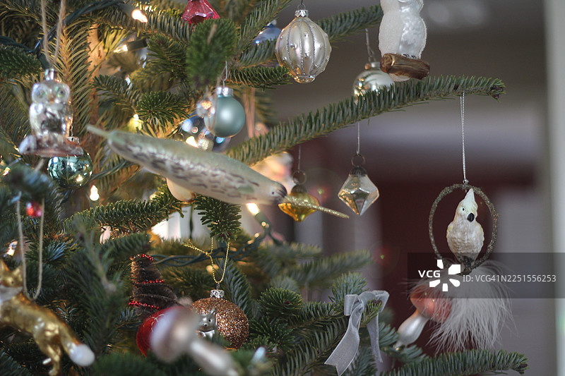 复古风格的独角鲸装饰品。闪闪发光的圣诞装饰品系列装饰着一棵新鲜的圣诞树。航海和海洋主题的装饰品。弗雷泽冷杉。图片素材