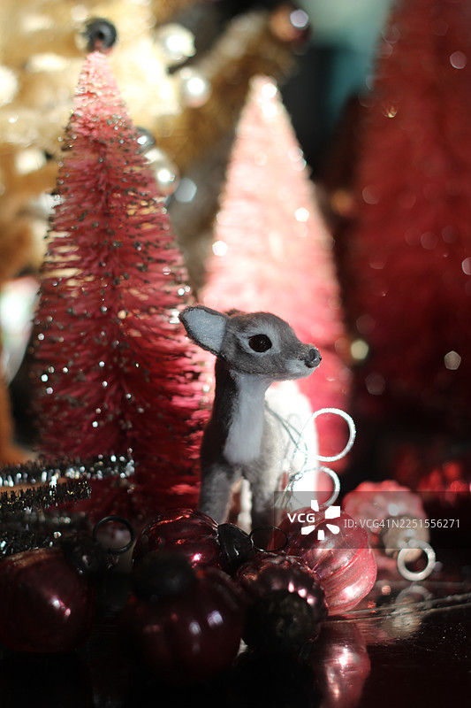 一套复古风格的瓶刷圣诞树装饰着房间，充满了节日气氛。还有驯鹿和粉色装饰品。图片素材