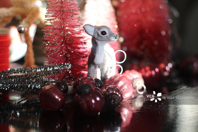 一房间装饰着复古风格的瓶刷圣诞树，以迎接节日。还有驯鹿、线轴和粉色装饰品。图片素材