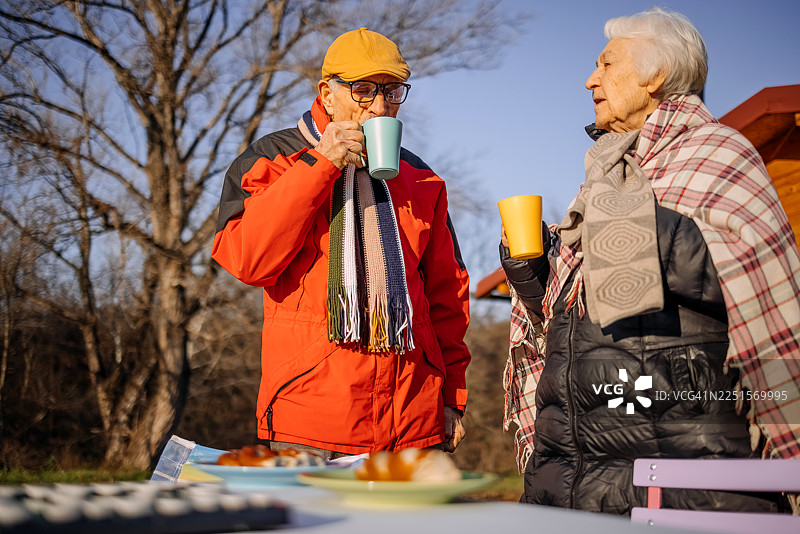 冬天，老人们在山上的小屋前一起在户外度过时光图片素材