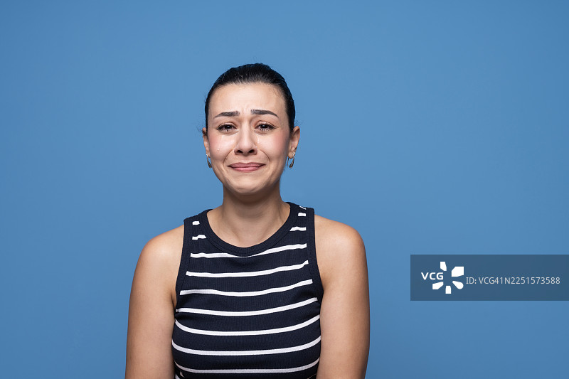 一位表情悲伤、含泪的女性向前看图片素材