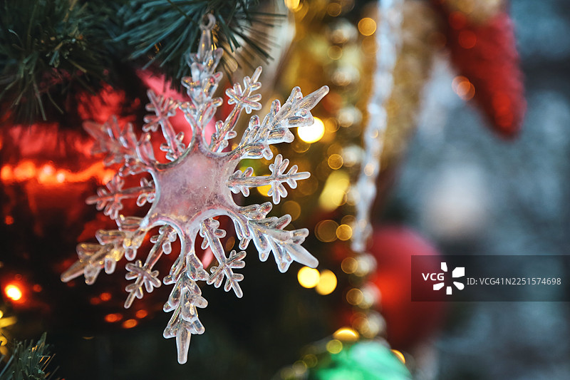 装饰着奶油色雪花造型饰品、小摆设和发光灯饰的节日圣诞树图片素材