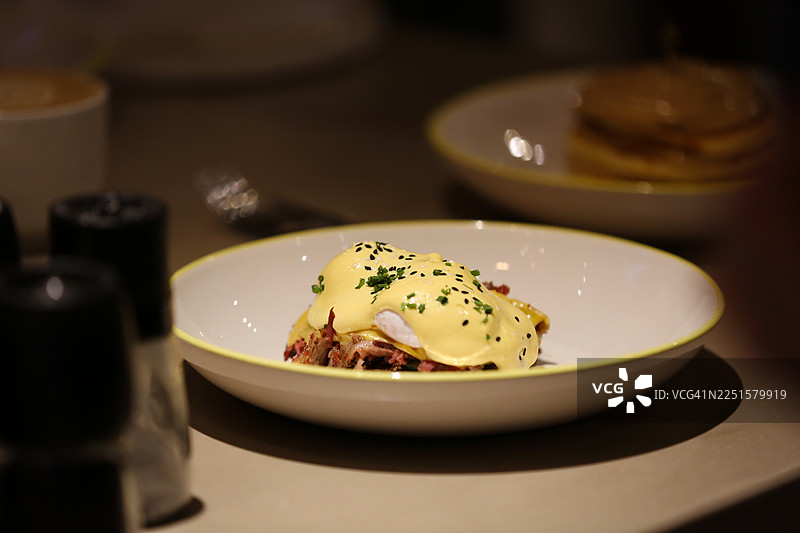 早餐时光。当地咖啡馆里的班尼迪克蛋配葱花，已准备好享用。图片素材