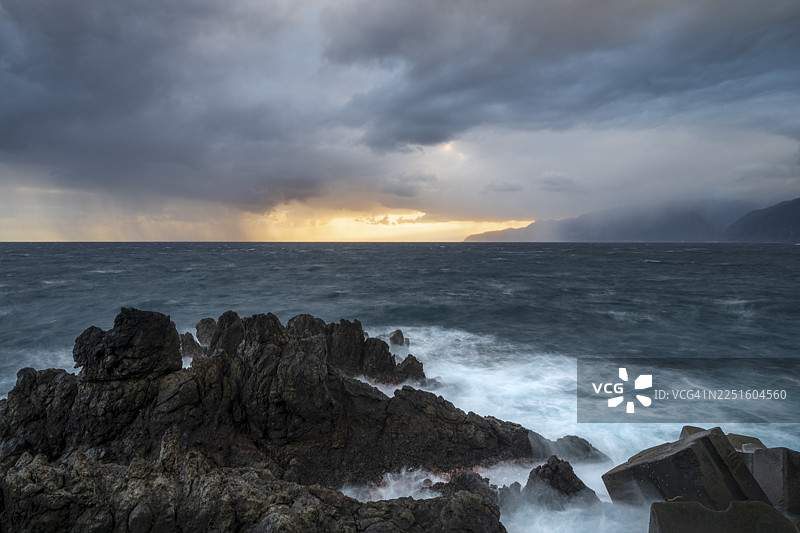 日出、海浪和岩石，葡萄牙马德拉波尔图莫尼什海岸图片素材