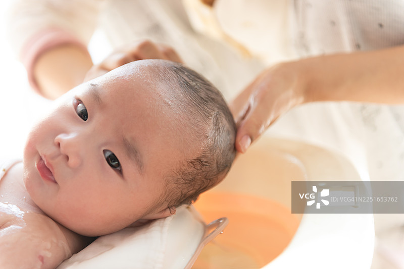 特写：母亲在家中给婴儿洗澡图片素材