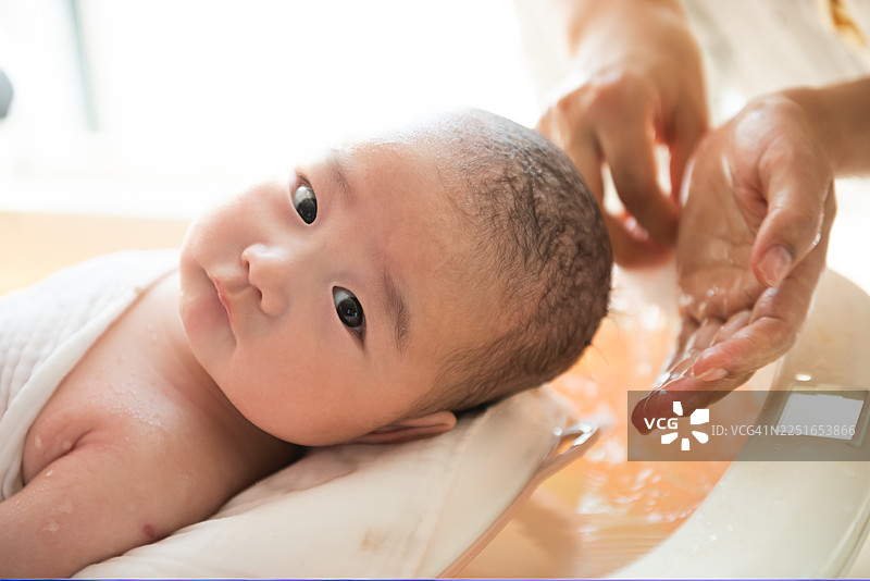 特写：母亲在家中为婴儿洗澡图片素材