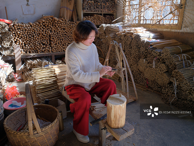 一位亚洲女性在制作油纸伞图片素材