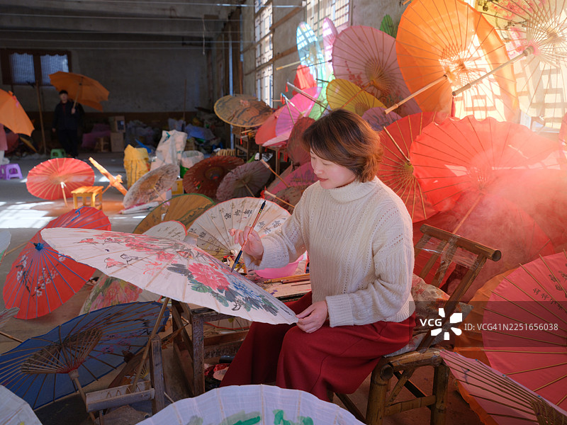 一位亚洲女性正在制作油纸伞图片素材