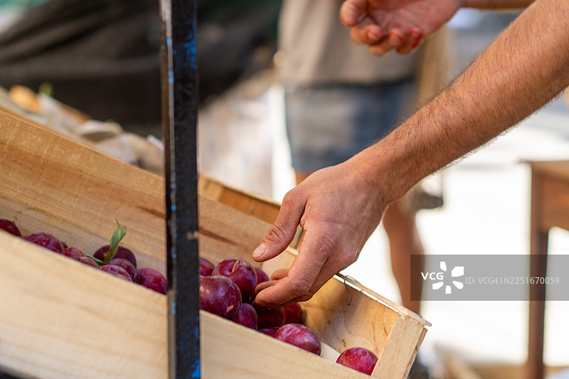 特写：店主为顾客挑选蔬菜图片素材