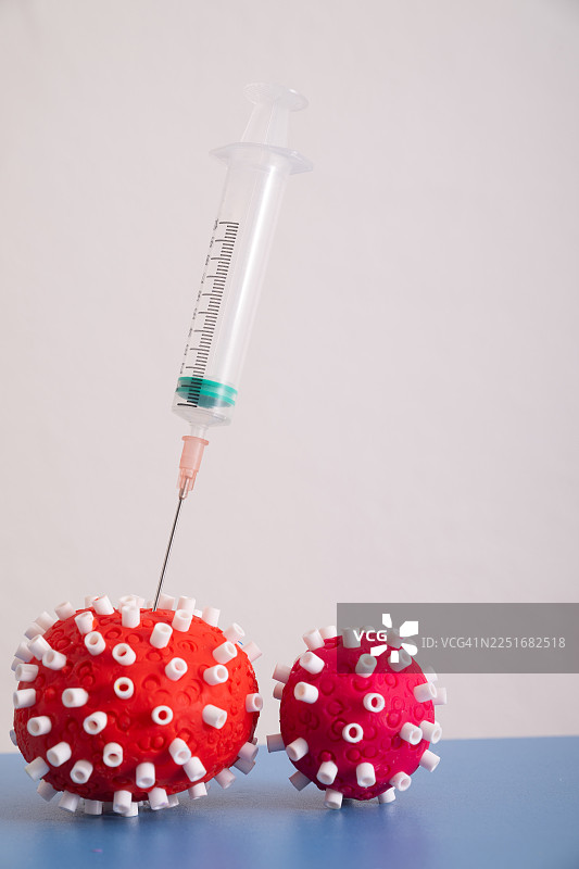 注射器将疫苗或解毒剂注入病毒（由粘土制成），象征着健康安全图片素材