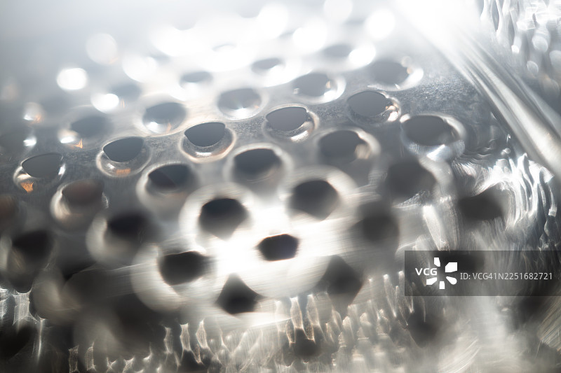 模糊的金属结构带有圆形孔洞，象征着安全。图片素材