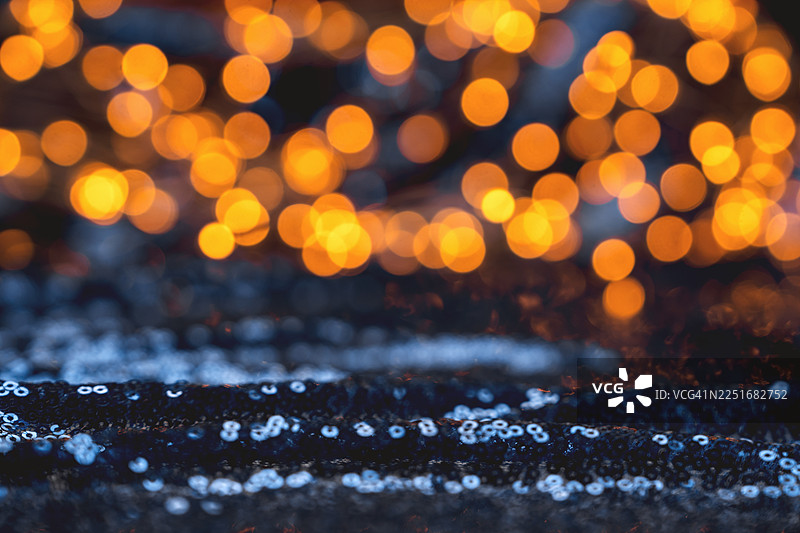 抽象的节日蓝色背景，带有金色串灯和闪光散景模型图片素材