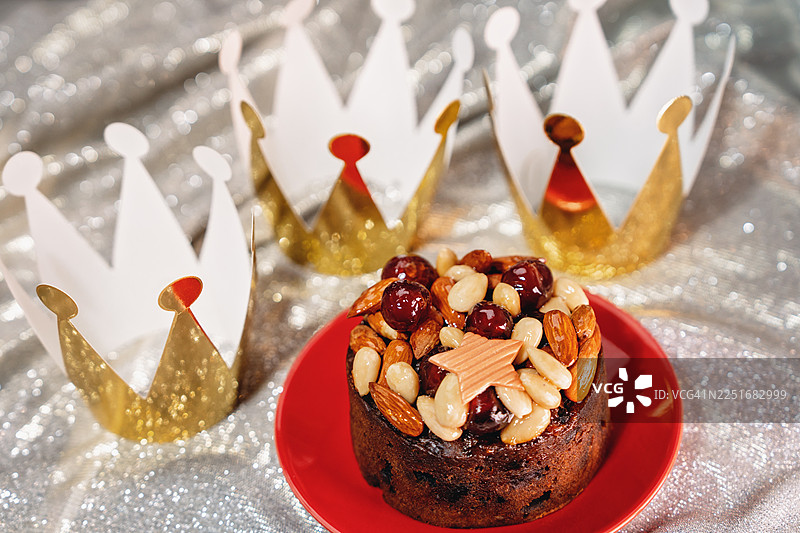 三位国王或智者与显现节的概念，背景闪耀着金色的皇冠。1月6日，国王节的果味布丁蛋糕。图片素材