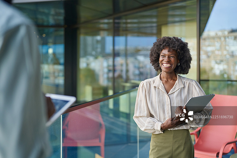 一位快乐的非裔美国女商人正在会议中拿着笔记本电脑图片素材