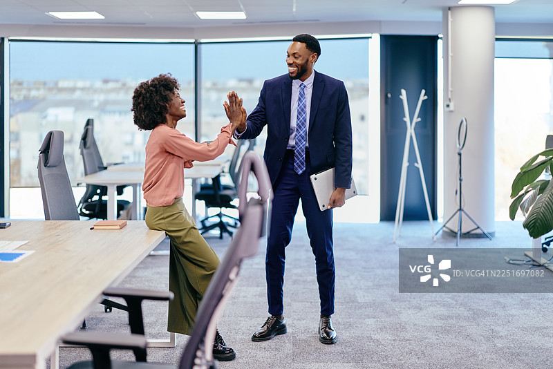 办公室里的同事们击掌庆祝成功图片素材