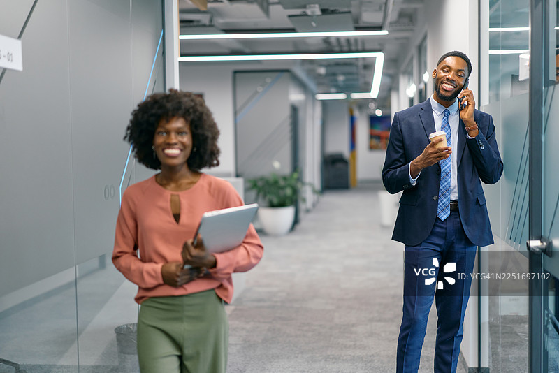 商务人士走在现代办公室的走廊里图片素材