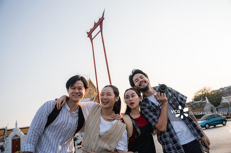 一群朋友开心地在曼谷热闹的街头漫步，享受着共同的当日游图片素材