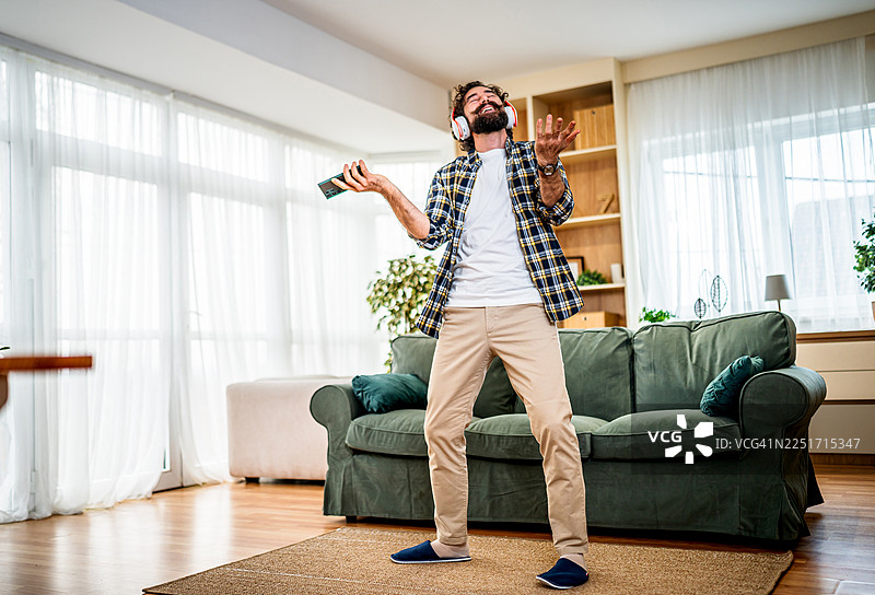 快乐的男人在家随着音乐跳舞图片素材