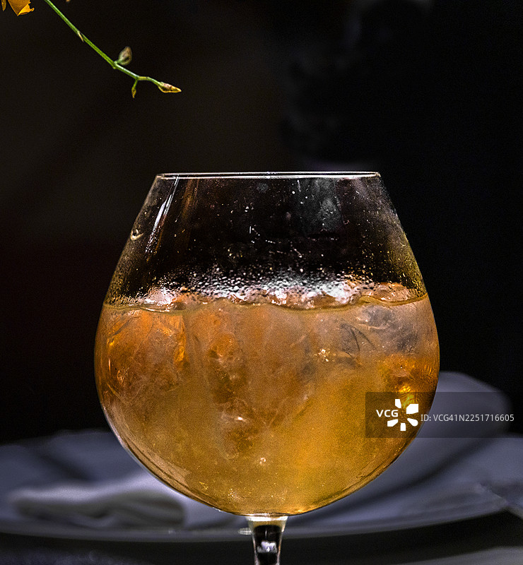 黑色背景上的一杯冰镇的Aperol Spritz鸡尾酒特写。图片素材