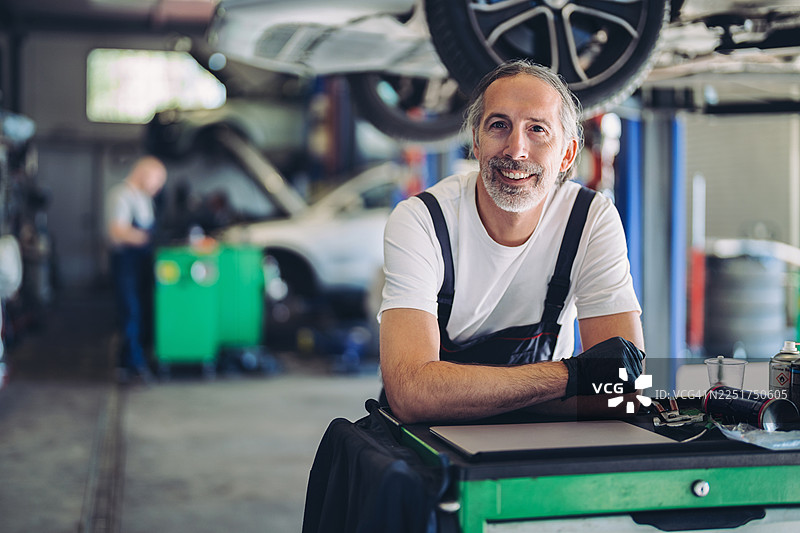 车库里一位微笑的汽车修理工肖像图片素材