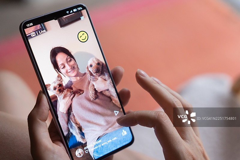 女子在家使用手机观看社交媒体图片素材