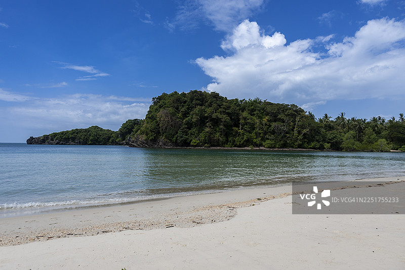 泰国沙敦府塔路涛岛（Koh Tarutao）一片宁静的白色沙滩，在晴朗的蓝天下延伸，海水清澈见底。图片素材