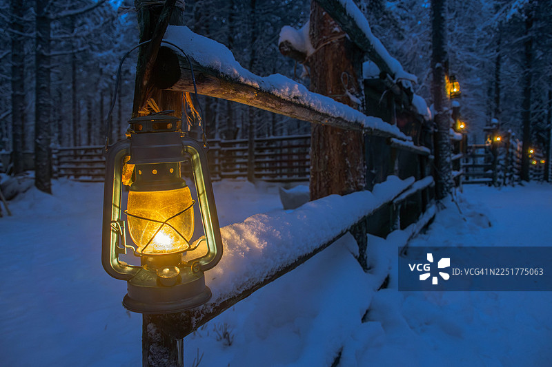 芬兰拉普兰雪林中亮灯的灯笼栅栏图片素材